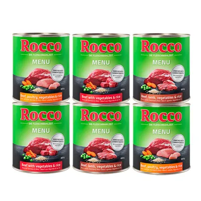 Šest pločevink Rocco Menu, vidne različice: Beef, poultry, vegetables & rice; Beef with vegetables & rice; Beef, lamb, vegetables & rice. Na embalaži so slike mesa, zelenjave in riža.