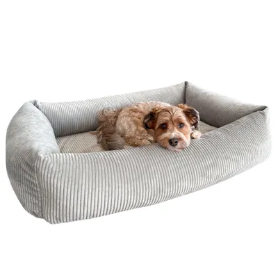 Lettino per animali domestici rettangolare, a coste, in grigio chiaro con bordo rialzato. Un animale riposa comodamente al suo interno.