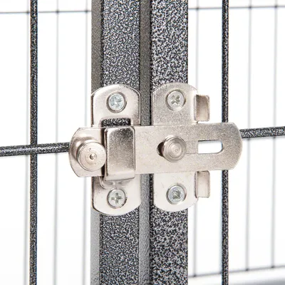 Fermeture métallique sur grille en métal, vue rapprochée du loquet fixé par des vis. Convient pour identifier le système de verrouillage d’une cage ou parc pour animaux.