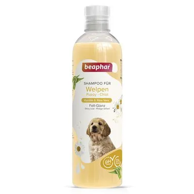 Frasco de champô beaphar para cachorros, texto visível: 'SHAMPOO FÜR Welpen Puppy Chiot, Kamille & Aloe Vera, Fell-Glanz', imagem de cachorro e símbolos pH neutro e 0% corantes.
