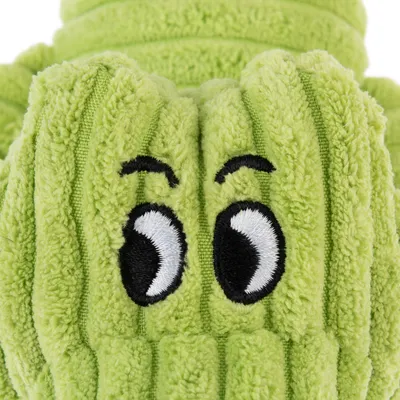 Green plush toy with embroidered eyes and textured surface.