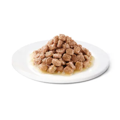 Närbild av bruna köttbitar i sås, serverade på en vit tallrik.