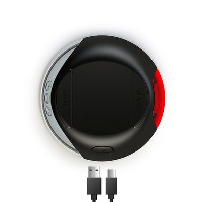 Schwarzes Gerät mit Ein-/Ausschalter, rotem Licht und USB-Anschluss. Zwei USB-Kabel sichtbar.