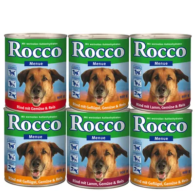 Seis latas de comida húmida para cão Rocco Menue, 800 g cada. Variedades visíveis: Rind mit Gemüse & Reis, Rind mit Geflügel, Gemüse & Reis, Rind mit Lamm, Gemüse & Reis.