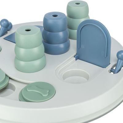 Кръгла бяла играчка със сини елементи, включително вратички, лостчета и части за подреждане. Подпомага интерактивна игра.