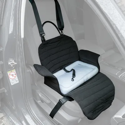 Protezione per sedile auto nera con superficie imbottita, cintura di sicurezza e pareti laterali protettive. Cinghie di fissaggio visibili per un'installazione sicura sul sedile auto.
