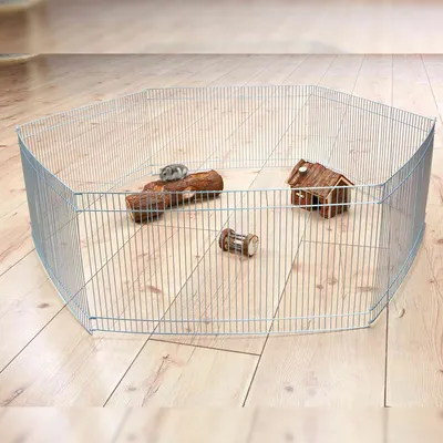 Sechseckiger Metall-Freilauf mit Gitterwänden, Holzspielzeug und Häuschen auf hellem Holzboden. Geeignet für kleine Haustiere. Sechseckiger Metall-Freilauf mit Gitterwänden, Holzspielzeug und Häuschen auf hellem Holzboden. Geeignet für kleine Haustiere.