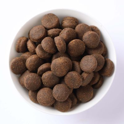 Ciotola con crocchette marroni e rotonde. L'immagine del prodotto mostra la forma e la taglia dei singoli pellet.