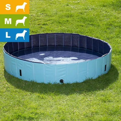 Piscine pliable bleue pour chiens, posée sur l’herbe. Icônes indiquant trois tailles disponibles : S, M, L avec silhouettes de chiens.
