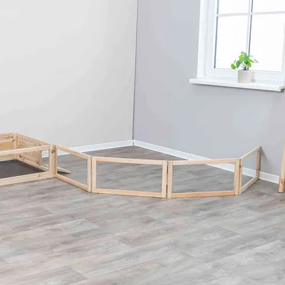 Holz-Freigehege mit transparenten Gitterwänden, geeignet für Innenräume. Gehege in rechteckiger Form auf grauem Laminatboden neben einem Fenster.