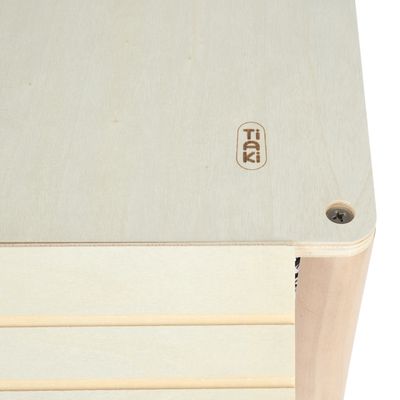 Tiaki-логотип на светлом деревянном материале, виден винт в углу. Изделие из дерева с гладкой поверхностью и горизонтальными полосами.