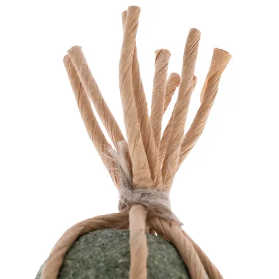 Juguete de materiales naturales: piedra verde con tiras de papel beige trenzadas, atado para juego interactivo.