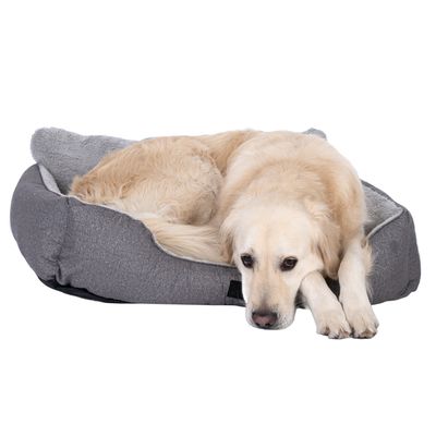 Cane sdraiato in un letto per cani grigio con imbottitura morbida.