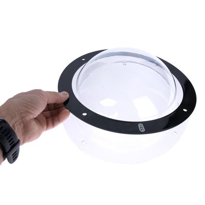 Hand houdt een transparante kunststof koepel met zwarte rand en Trixie-logo, geschikt voor montage.