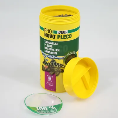 Boîte ouverte de JBL Pro Novo Pleco, aliment pour poissons, texte visible : SAUGWELSE, PLÉCOS, MEERVALLEN, LORICARIDI, WAFER M SINKING, 100 % ORIGINAL JBL QUALITY MADE IN GERMANY.
