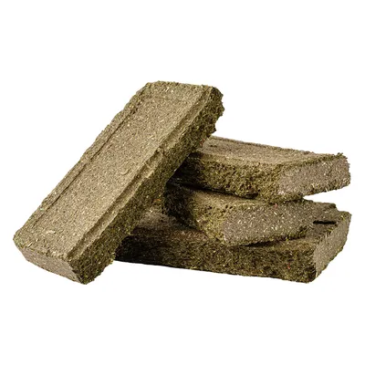 Gröna höpellets, rektangulär form, staplade. Synlig struktur av pressat hö.