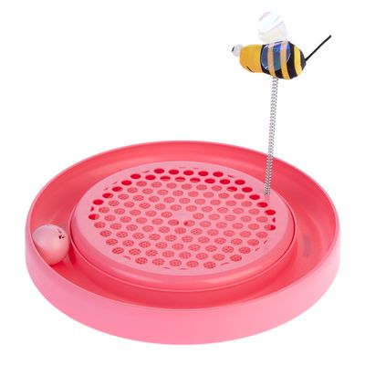 Rund leksak i rosa med hålplatta, integrerad bollbana och fjäder med plyschbi på spiral.