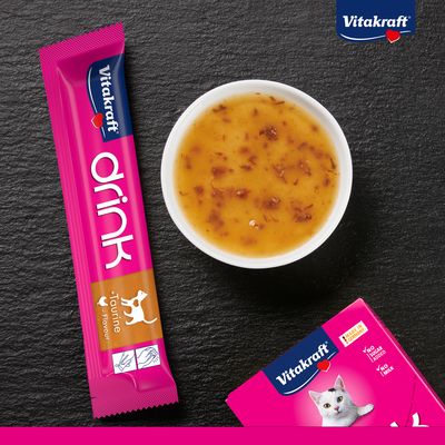 Vitakraft Drink med taurin för katter, flytande snacks utan tillsatt socker och utan mjölk. Förpackning och serverad portion synliga.