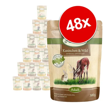 Pakkaus: Kaninchen & Wild, Adult, 300 g. Näkyvissä myös 48x-merkintä ja useita saman tuotteen pusseja taustalla. Teksti englanniksi: Rabbit & Game with brown rice, apple and linseed oil.