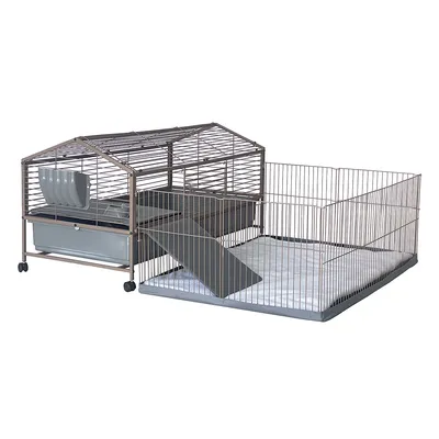 Cage en métal avec toit incliné, bac plastique, rampe d’accès et enclos attenant sur tapis. Mangeoire suspendue visible à l’intérieur. Roulettes sous la cage.