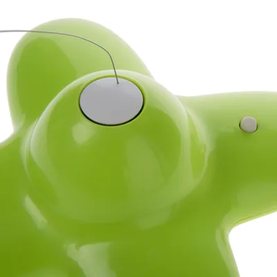 Grønt legetøj af plast med hvid knap og tråd, egnet til interaktiv leg.