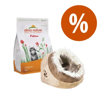 Almo Nature Kitten 2–12 months 2 kg, sacco di crocchette per gattini, accanto a cuccia beige in tessuto con gatto all'interno e simbolo percentuale arancione per offerta.