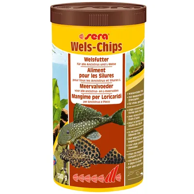 Корм для сомов Sera Wels-Chips, банка 380 г. Видны изображения двух аквариумных рыб и текст на нескольких языках: Welsfutter, Aliment pour les Silures, Meervalvoeder, Mangime per Loricaridi.