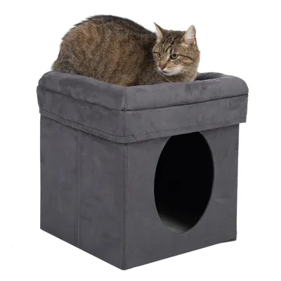Grijze kattenhol met gevoerde ligplek, kat zit bovenop. Ronde opening voor toegang tot de hol zichtbaar.