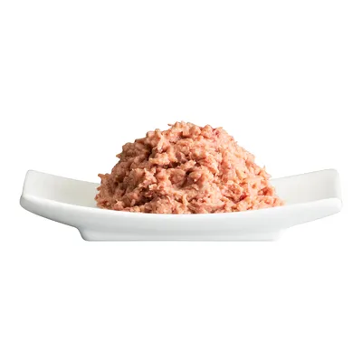 Närbild av våtfoder för djur på en vit tallrik, rosa och köttig konsistens.