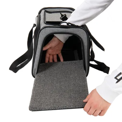 Borsa da trasporto con fondo in moquette grigia, ingresso aperto e mano che mostra l'interno. Adatta al trasporto di pet.
