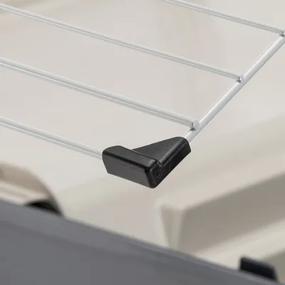 Detailní záběr kovové mřížky s černou plastovou ochranou v rohu, vhodné pro přepravky pro zvířata.