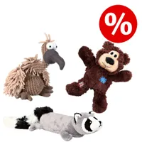 Trois jouets en peluche pour chien : un vautour marron, un ours brun et un raton laveur gris. Symbole de pourcentage rouge indiquant une offre ou promotion visible.