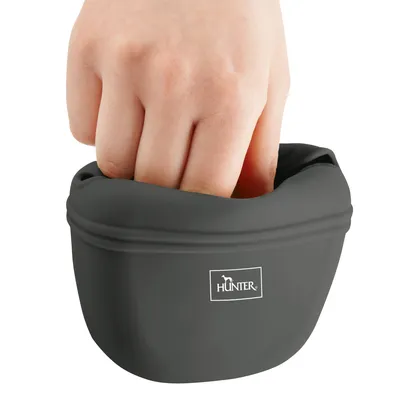 Main insérée dans une gamelle souple noire en silicone avec le nom de la marque HUNTER visible sur le devant.