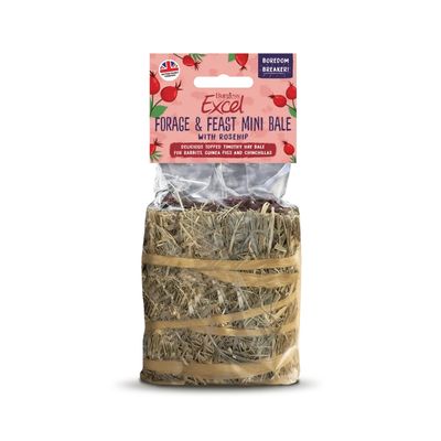 Two rabbits are eating together from a round hay bale with dried herbs on a plate.
