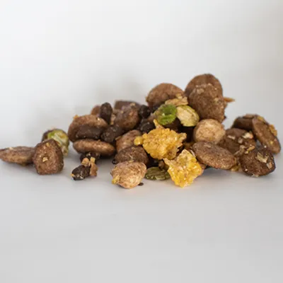 Mixed dry pet food pieces in various shapes and colours displayed on a plain surface, showing the texture and variety of the product.