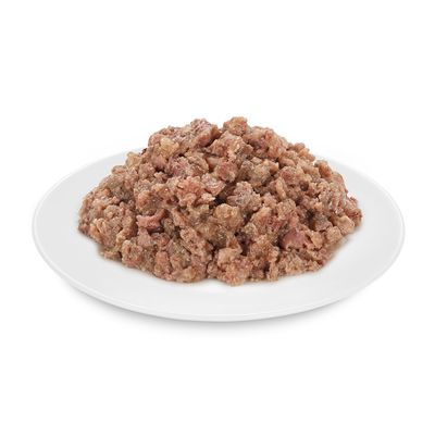 Közelkép tálalt nedves eledelről fehér tányéron, látható az eledel állaga.