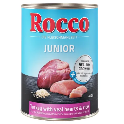Lata de Rocco Junior, 400 g, con texto visible: 'Turkey with veal hearts & rice', imágenes de corazón, carne y arroz. Indica calcio y 'Supports healthy growth'.