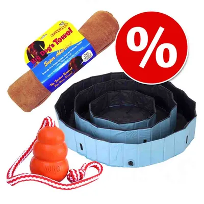 Set con toalla Big Dog's Towel, piscina plegable azul y juguete naranja KONG con cuerda. Símbolo de porcentaje en círculo rojo indicando oferta o descuento.