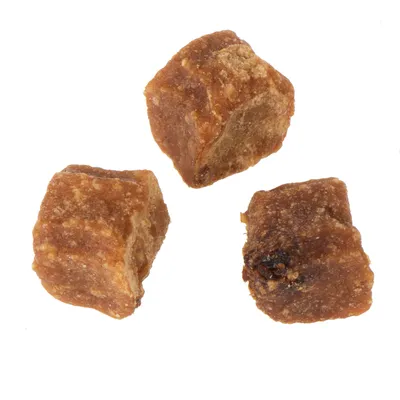 Trois cubes de friandises brunes pour animaux, sans emballage ni marque visible, posés sur fond blanc.