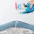 Beaphar Multi Frisch, Probiotic Katzenstreu-Zusatz wird in eine Katzentoilette gestreut. Verpackung zeigt Katze und Hinweise zu Geruchsneutralisierung und biologischer Abbaubarkeit.