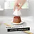 Hand lifting white plastic container from wet pet food on plate, text reads: Reveal an exquisite serving experience
