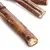 Snack da masticare essiccati a forma di bastoncino, superficie naturale marrone con struttura visibile.