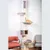 Cat tree with multiple levels, sisal post, padded resting areas and cave. Orange cat lying on a hammock. Furniture in the background.