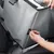 Hand fastening seat belt to grey transport box in car. Close-up of fastening loop.