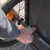 Montage eines Fahrradanhängers: Hand befestigt die Achse am Rad mit Schraube und Reflektor sichtbar.