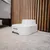 Fontana per acqua bianca con la scritta Closer Pets, posizionata su un tappeto davanti a un rivestimento in legno.