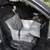 Grey car seat cushion with check pattern and safety belt, placed on a car seat. Suitable for safe transport of pets in the car.