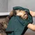 Hund wird mit einem grünen Handtuch abgetrocknet, das von einer Person gehalten wird.