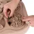 Hand places food piece into interactive toy with maze design for slow feeding.