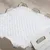 Superficie blanca y texturizada en una caja de madera. Foto de detalle del material, posiblemente para productos o accesorios para mascotas.